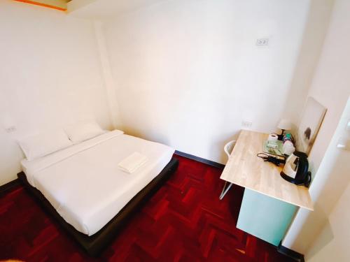 Yan NawaGO INN Silom - BTS Surasak station的小房间设有一张床和一张桌子