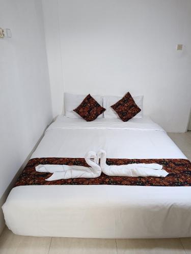 DemanganJogja Amor Hotel的一张白色的床,上面有两条白色毛巾