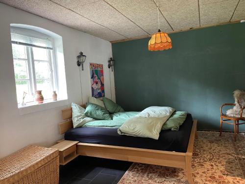 锡尔克堡Mormors Stue - Grethelund的绿色墙壁间的一张床位