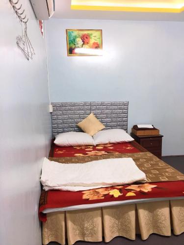 芽庄Motel&homestay Rồng Vàng的一间小卧室,配有一张带红色毯子的床