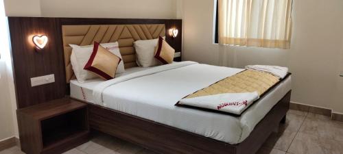 拉马纳塔普拉姆Starwin Residency的卧室配有一张带白色床单和枕头的大床。