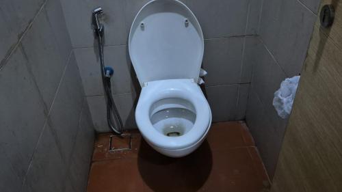 加尔各答Hours home的浴室位于隔间内,设有白色卫生间。