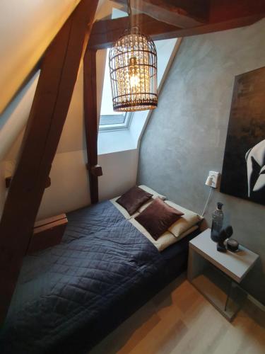 腓特烈斯塔Modern loftsleilighet的一间卧室配有一张床和一个吊灯