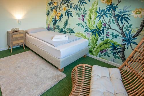 格洛米茨WannerHus Hotel的一间卧室配有一张床和藤椅
