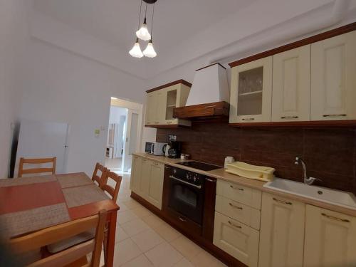 雅典Κατάλυμα στην πόλη Χαλάνδρι的厨房配有白色橱柜、桌子和水槽。