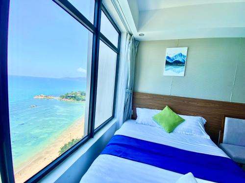 芽庄Ocean Dream Apartment Nha Trang的一间卧室设有一张床和一个带海滩的窗户