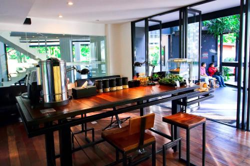 清迈查恩基安贝德酒店 - 仅限成人的厨房配有带椅子和窗户的大型木桌