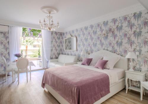 戛纳Cannes Imperial Croisette Palais Miramar的卧室配有1张床、1张桌子和1把椅子
