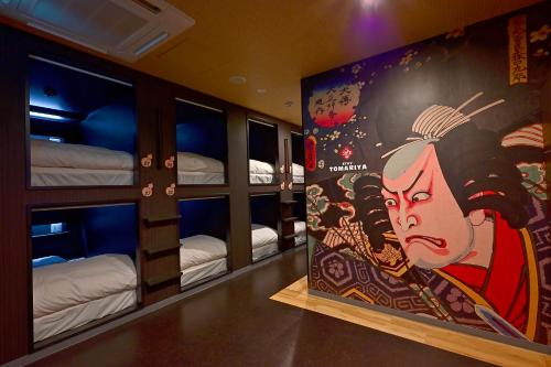 东京Hotel Tomariya Ueno的一间设有双层床的房间,配有一幅女画