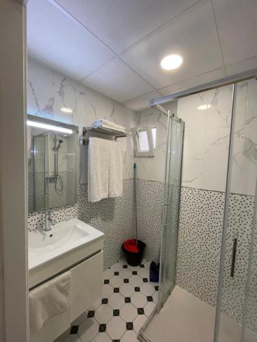 贝尼多姆Aparthotel Pelicano的带淋浴、水槽和玻璃淋浴间的浴室