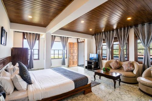 甘托克Sparrow Cherry Resort Near MG Marg的一间卧室配有一张床、一张沙发和一台电视。