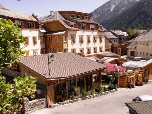 昂塞勒Hôtel Restaurant & Spa Les Autanes的享有以山脉为背景的小镇美景。