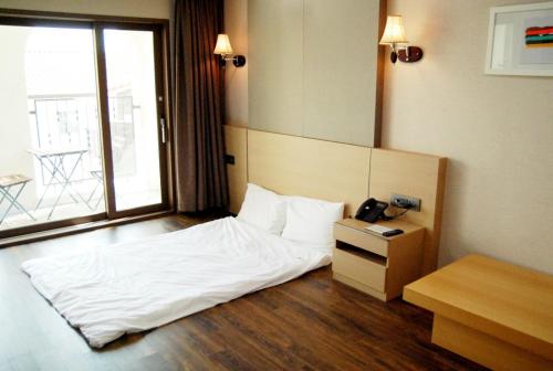 龙仁市勒松森林酒店的酒店客房,配有一张带电话的床