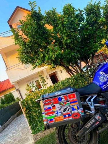采蒂涅Apartman Petar & Petra的停在房子前面的一辆蓝色摩托车