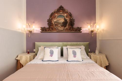 威尼斯艾尔格雷奇奢华公寓的一间卧室配有一张带两张桌子和镜子的床
