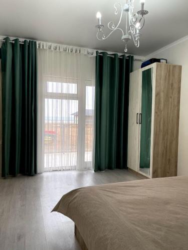 博斯特里Ak Line的一间卧室配有绿色窗帘、一张床和一个吊灯