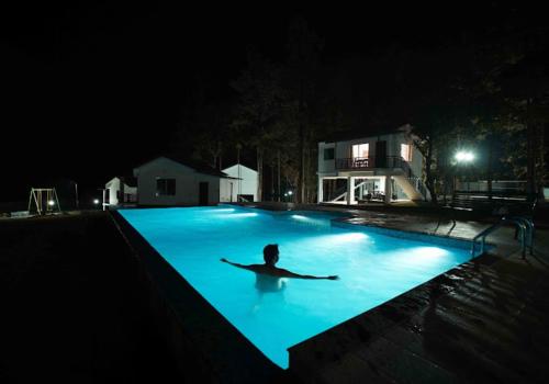 PadinjaratharaMisty Dam Wayanad Premium Resort With Banasura Dam View的夜间躺在游泳池里的人