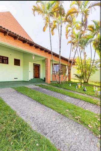 科蒂亚Casa em Cotia的前面有棕榈树的房子
