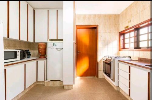 科蒂亚Casa em Cotia的厨房配有白色冰箱和微波炉