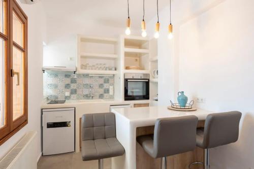 KrotiriTheodora's Suite的厨房配有白色的柜台和椅子