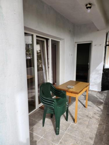 桑丹斯基Apartment Lachevi的一张绿色椅子,坐在木桌旁