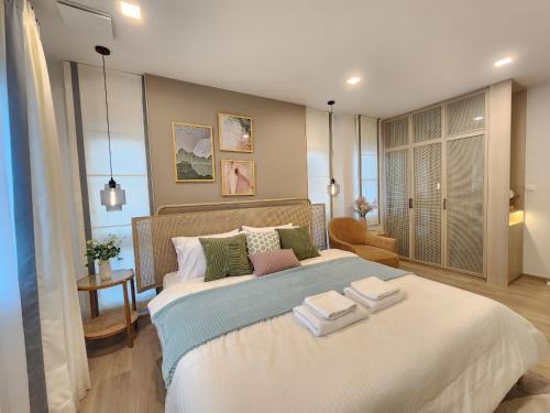 Ban Thap NangNARAH的一间卧室配有一张大床和两条毛巾