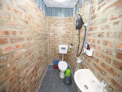 瓜拉丁加奴OYO 90960 Rajawali D'cabin Chalet Roomstay的砖墙浴室设有卫生间和水槽