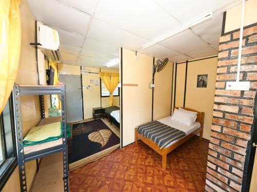 瓜拉丁加奴OYO 90960 Rajawali D'cabin Chalet Roomstay的小房间,设有床和砖墙