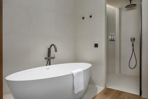 加瓦AC Hotel Gava Mar的带淋浴的浴室配有白色浴缸。