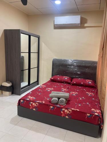拿笃B&K Homestay Lahad Datu的一间卧室配有一张红色棉被的床