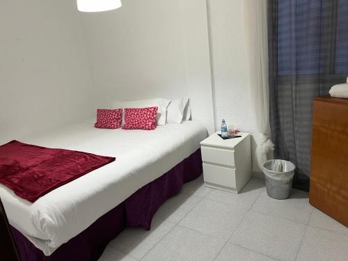 卡塔罗哈Habitación por días的一间卧室配有一张带红色枕头的床
