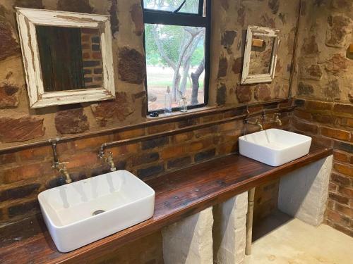 马加利斯堡Soetvlei Tented Farm Camp的带窗户的浴室的柜台上有两个水槽