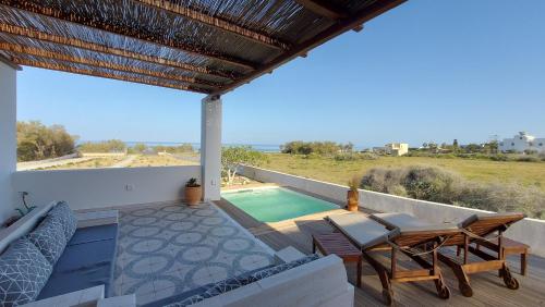 莫诺利索斯Sea breeze houses的一个带桌椅的庭院和一个游泳池