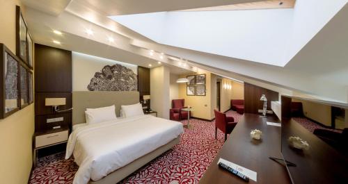 乌法巴施克瑞亚酒店的卧室配有一张白色大床和一张书桌