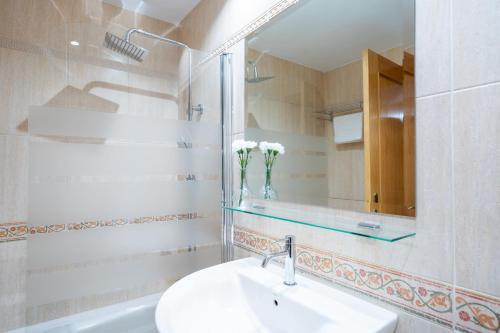 巴利亚多利德Apartamentos GO - Génova Parquesol - Parking Gratuito的白色的浴室设有水槽和镜子