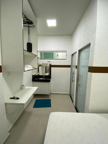 里约布兰科POUSADA TORRE FORTE ac的厨房配有白色橱柜和蓝色地毯。