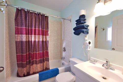 悉尼Jacques Cartier Motel的浴室配有盥洗盆、卫生间和浴缸。
