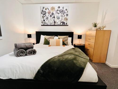 斯劳Bright & Spacious Flat - Perfect for Exploring London , Slough & Windsor!的一间卧室配有一张大床和一个木制梳妆台