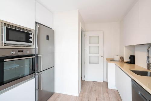 阿罗约德莱恩科缅达Apartamentos Go - Chalet Calera的厨房配有不锈钢冰箱和水槽