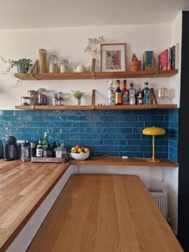 伦敦Charming bedroom in artist studio的厨房设有蓝色的墙壁和木桌