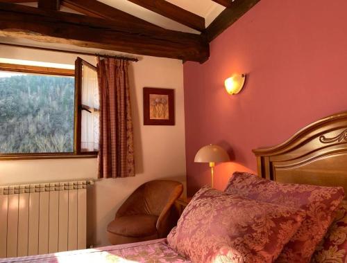 图里恩奥Picos de Europa Suites and Rooms的卧室配有床、椅子和窗户。