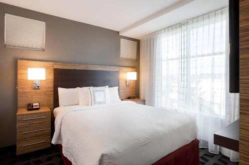 福斯特城圣马特奥福斯特城万豪广场套房酒店的一间设有大床和窗户的酒店客房
