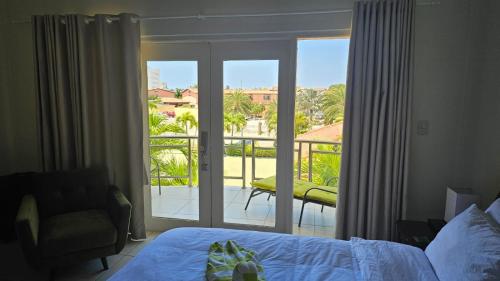 棕榈滩Eagle Beach Cozy Condo的一间卧室设有一张床,享有阳台的景色