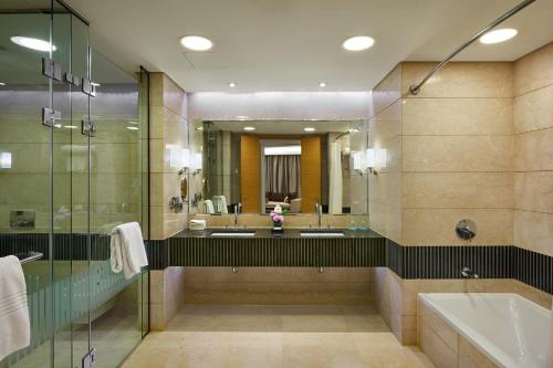 开罗乐蒙雷蒂恩开罗机场的浴室设有2个水槽、浴缸和镜子
