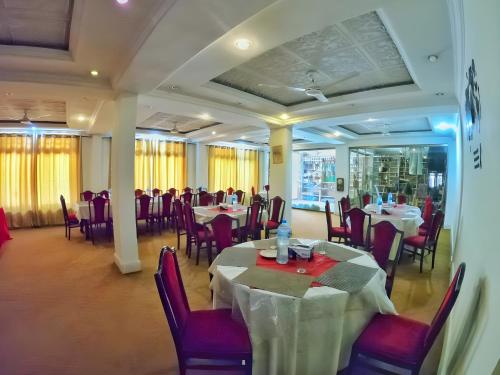 锡卡都Baltistan Continental的餐厅内带桌椅的用餐室