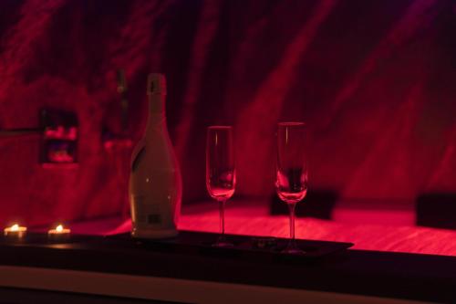 圣埃拉莫因科莱Blue Hole Jacuzzi Suite e B&B Santeramo in Colle的桌子上放有一瓶葡萄酒和两杯酒