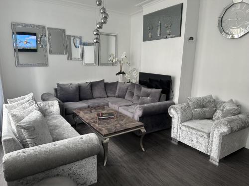 大雅茅斯Impeccable 3-Bed House in Great Yarmouth的客厅配有沙发、两把椅子和一张桌子