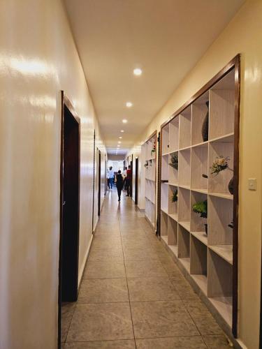 内罗毕Nomad Paradise Hotel的建筑物的走廊,有人沿着走廊走