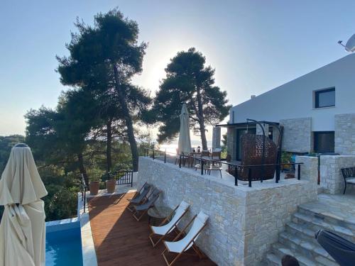 斯基亚索斯镇Allure Luxury Villas的一个带躺椅的庭院和一个游泳池