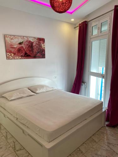 突尼斯Appartement coeur de ville Tunis的卧室配有白色的床和窗户。